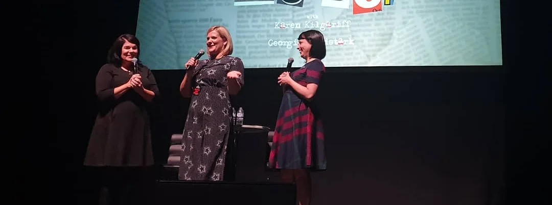 The Police Coach Olivia Standbridge on stage with a microphone stood between Karen Kilgariff and Georgia Hardstark at the Hammersmith Apollo, London for My Favorite Murder live show.